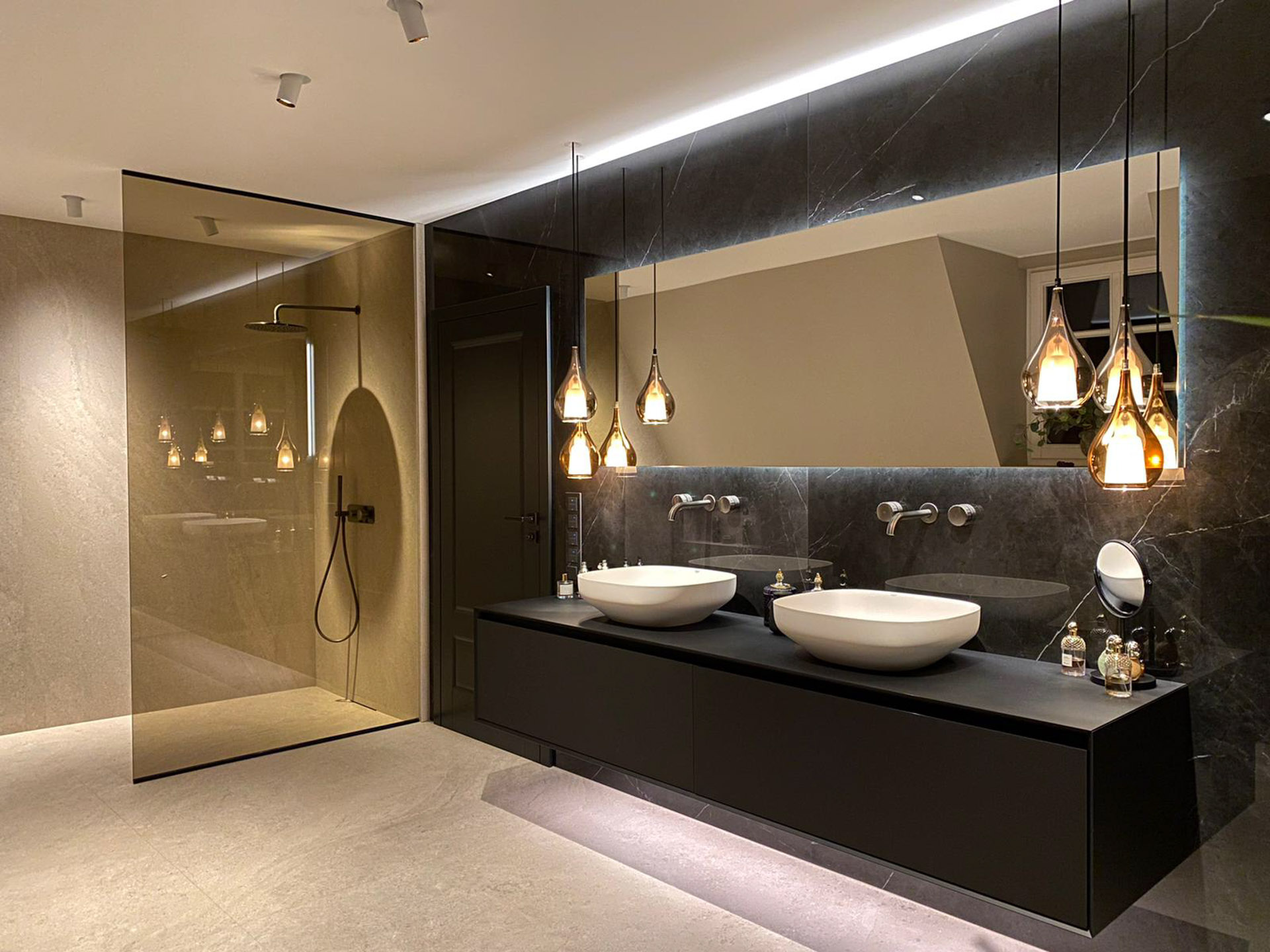 Modernes Badezimmer mit Doppelwaschtisch, schwarzer Marmorwand und begehbarer Dusche mit Glaswand