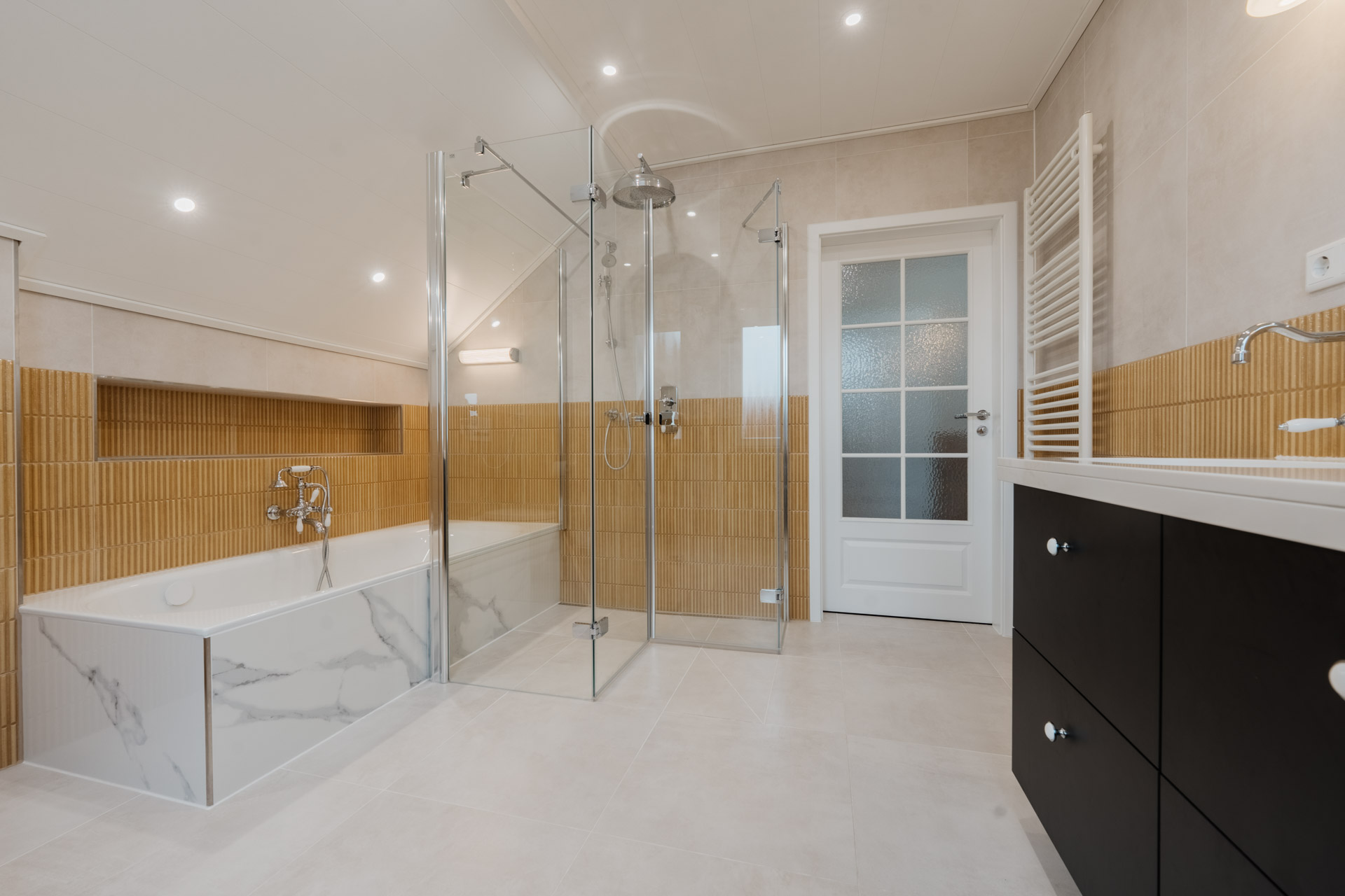 Modernes Badezimmer mit Badewanne, Glasdusche, Waschtisch und hellen Fliesen